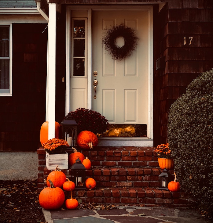 front porch with fall decor and pumpkins